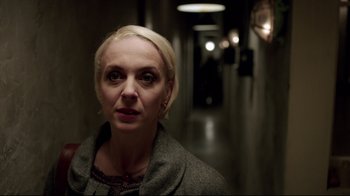 Movie still from “Sherlock” (2010), created by Steven Moffat – A woman standing in a dark hallway looking at the camera; Close Up shot, Over the shoulder angle