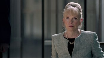 Movie still from “Sherlock” (2010), created by Steven Moffat – An older woman wearing a gray jacket and a pearl necklace; Close Up shot, Over the shoulder angle