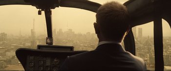 Movie still from “Spectre” (2015), directed by Sam Mendes – A man is looking out the window of an airplane; Medium shot, Over the shoulder angle