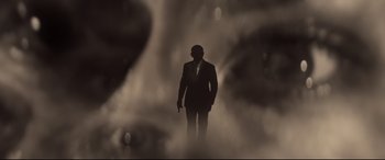 Movie still from “Spectre” (2015), directed by Sam Mendes – A man in a suit and tie standing in the fog; Extreme Close Up shot, Low angle