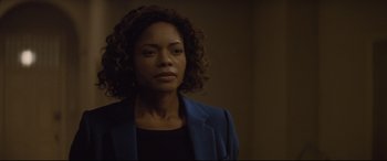 Movie still from “Spectre” (2015), directed by Sam Mendes – A woman in a blue jacket is standing in a room; Close Up shot, Over the shoulder angle