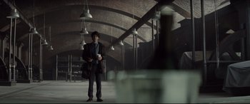 Movie still from “Spectre” (2015), directed by Sam Mendes – A man holding a cup standing in an empty room; Wide shot, Low angle