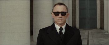 Movie still from “Spectre” (2015), directed by Sam Mendes – A man wearing a suit and sunglasses; Close Up shot, Low angle