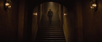 Movie still from “Spectre” (2015), directed by Sam Mendes – A man walking down a set of stairs; Wide shot, Low angle