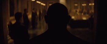 Movie still from “Spectre” (2015), directed by Sam Mendes – A man's face is seen in the dark; Close Up shot, Over the shoulder angle