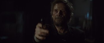 Movie still from “Spectre” (2015), directed by Sam Mendes – An old man holding a gun in a dark room; Close Up shot, Over the shoulder angle