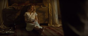 Movie still from “Spectre” (2015), directed by Sam Mendes – A woman sitting on the ground holding a glass of wine; Wide shot, High angle