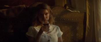 Movie still from “Spectre” (2015), directed by Sam Mendes – A woman holding a glass of red wine in her hand; Medium shot, Over the shoulder angle