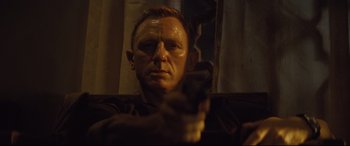 Movie still from “Spectre” (2015), directed by Sam Mendes – A person holding a gun in a room; Close Up shot, Low angle