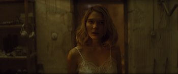 Movie still from “Spectre” (2015), directed by Sam Mendes – A woman in a white dress standing next to a door; Medium shot, Low angle