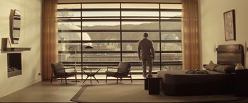 Movie still from “Spectre” (2015), directed by Sam Mendes – A man standing in front of a large window; Extreme Wide shot, Low angle