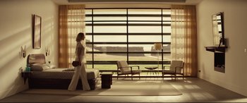 Movie still from “Spectre” (2015), directed by Sam Mendes – A woman walking in front of a large open window; Wide shot, Low angle