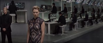 Movie still from “Spectre” (2015), directed by Sam Mendes – A woman standing in front of computer monitors; Medium shot, Over the shoulder angle
