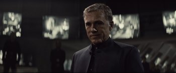 Movie still from “Spectre” (2015), directed by Sam Mendes – A person wearing a suit and tie; Close Up shot, Over the shoulder angle