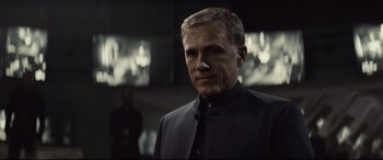 Movie still from “Spectre” (2015), directed by Sam Mendes – A person wearing a suit and tie; Close Up shot, Over the shoulder angle