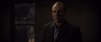 Movie still from “Spectre” (2015), directed by Sam Mendes – A person wearing a suit and tie; Close Up shot, Over the shoulder angle