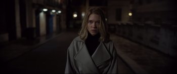 Movie still from “Spectre” (2015), directed by Sam Mendes – A woman in a black top and a white coat; Medium shot, Low angle
