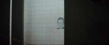 Movie still from “Spectre” (2015), directed by Sam Mendes – A picture of a man's face on a wall; Close Up shot, High angle