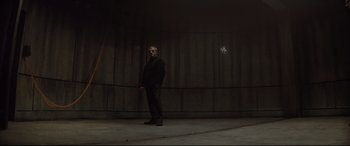 Movie still from “Spectre” (2015), directed by Sam Mendes – A man standing in front of a wall with a star in the background; Wide shot, Low angle