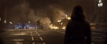 Movie still from “Spectre” (2015), directed by Sam Mendes – A car on fire on the side of the road; Wide shot, Over the shoulder angle