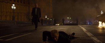 Movie still from “Spectre” (2015), directed by Sam Mendes – A man laying on the ground in the middle of the street; Wide shot, Low angle