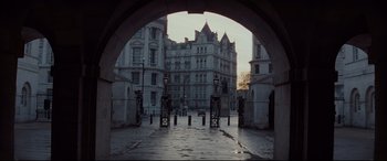 Movie still from “Spectre” (2015), directed by Sam Mendes – An archway leading to a large building in a city; Extreme Wide shot, Low angle