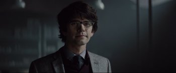 Movie still from “Spectre” (2015), directed by Sam Mendes – A man in a suit and tie wearing glasses; Close Up shot, Over the shoulder angle