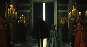 Movie still from “Elizabeth: The Golden Age” (2007), directed by Shekhar Kapur – A woman and a child are standing in front of a doorway; Wide shot, Over the shoulder angle