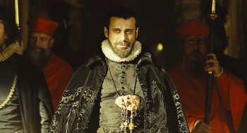 Movie still from “Elizabeth: The Golden Age” (2007), directed by Shekhar Kapur – A man dressed in renaissance clothing with a beard; Medium shot, Over the shoulder angle