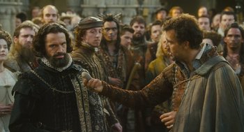 Movie still from “Elizabeth: The Golden Age” (2007), directed by Shekhar Kapur – A group of men standing next to each other in a room; Medium shot, Over the shoulder angle