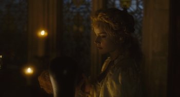 Movie still from “Elizabeth: The Golden Age” (2007), directed by Shekhar Kapur – A young girl in a white dress is looking at a mirror; Medium shot, Low angle