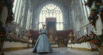 Movie still from “Elizabeth: The Golden Age” (2007), directed by Shekhar Kapur – A woman in a blue dress standing in front of an altar in a church; Wide shot, Low angle