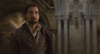 Movie still from “Elizabeth: The Golden Age” (2007), directed by Shekhar Kapur – A man with a beard wearing a brown jacket; Medium shot, Over the shoulder angle