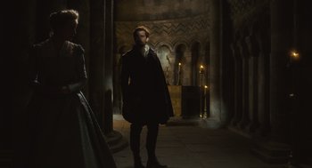 Movie still from “Elizabeth: The Golden Age” (2007), directed by Shekhar Kapur – A man and a woman standing in a dark room; Wide shot, Low angle