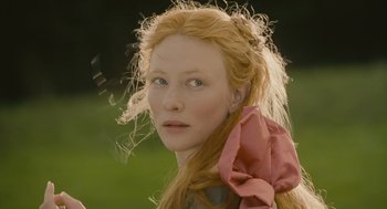 Movie still from “Elizabeth: The Golden Age” (2007), directed by Shekhar Kapur – A woman with long red hair wearing a pink bow around her neck; Close Up shot, Over the shoulder angle