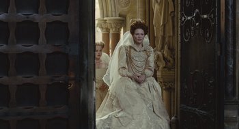 Movie still from “Elizabeth: The Golden Age” (2007), directed by Shekhar Kapur – A woman in a wedding dress sitting next to another woman in a wedding dress; Wide shot, Low angle