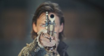 Movie still from “Elizabeth: The Golden Age” (2007), directed by Shekhar Kapur – A man holding a gun pointed at the camera; Close Up shot, Over the shoulder angle