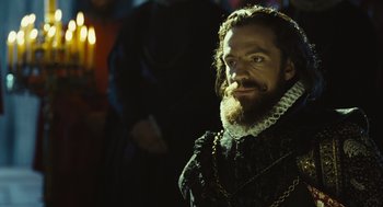 Movie still from “Elizabeth: The Golden Age” (2007), directed by Shekhar Kapur – A man with a long beard and a mustache; Close Up shot, Over the shoulder angle