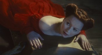 Movie still from “Elizabeth: The Golden Age” (2007), directed by Shekhar Kapur – A woman laying on the ground wearing a red dress; Close Up shot, Overhead angle