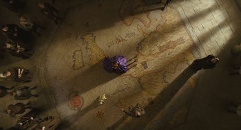 Movie still from “Elizabeth: The Golden Age” (2007), directed by Shekhar Kapur – An overhead view of a woman in a purple dress on a map; Extreme Wide shot, Overhead angle
