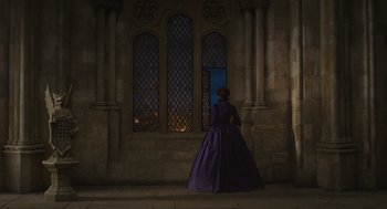 Movie still from “Elizabeth: The Golden Age” (2007), directed by Shekhar Kapur – A woman in a purple dress standing in front of a window at night; Wide shot, Over the shoulder angle