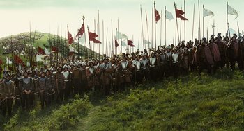 Movie still from “Elizabeth: The Golden Age” (2007), directed by Shekhar Kapur – A large group of people standing next to each other holding flags; Extreme Wide shot, High angle
