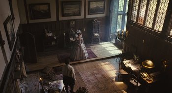 Movie still from “Elizabeth: The Golden Age” (2007), directed by Shekhar Kapur – A woman in a dress and a man in a suit in a living room; Extreme Wide shot, High angle