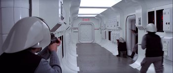 Movie still from “Star Wars: Episode IV - A New Hope” (1977), directed by George Lucas – A man taking a picture of a room in a space station; Wide shot, Over the shoulder angle