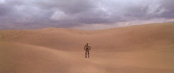 Movie still from “Star Wars: Episode IV - A New Hope” (1977), directed by George Lucas – A person standing in the middle of the desert; Extreme Wide shot, High angle