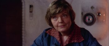 Movie still from “Star Wars: Episode IV - A New Hope” (1977), directed by George Lucas – An older woman wearing a blue jacket and a red scarf; Close Up shot, Over the shoulder angle