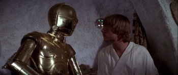 Movie still from “Star Wars: Episode IV - A New Hope” (1977), directed by George Lucas – A man standing next to a robot in a room; Close Up shot, Over the shoulder angle