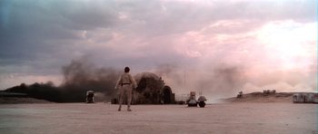 Movie still from “Star Wars: Episode IV - A New Hope” (1977), directed by George Lucas – A man standing in front of an exploding building; Extreme Wide shot, Low angle