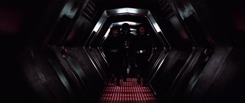 Movie still from “Star Wars: Episode IV - A New Hope” (1977), directed by George Lucas – A group of people standing inside of a tunnel; Wide shot, Low angle