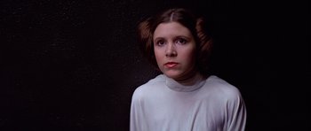 Movie still from “Star Wars: Episode IV - A New Hope” (1977), directed by George Lucas – A young woman in a white shirt and brown hair; Close Up shot, Low angle